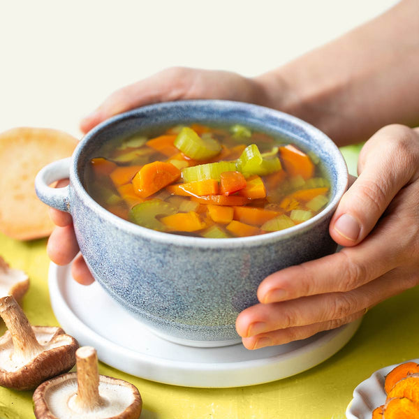 Hands holding a cup of Healing Broth Soup